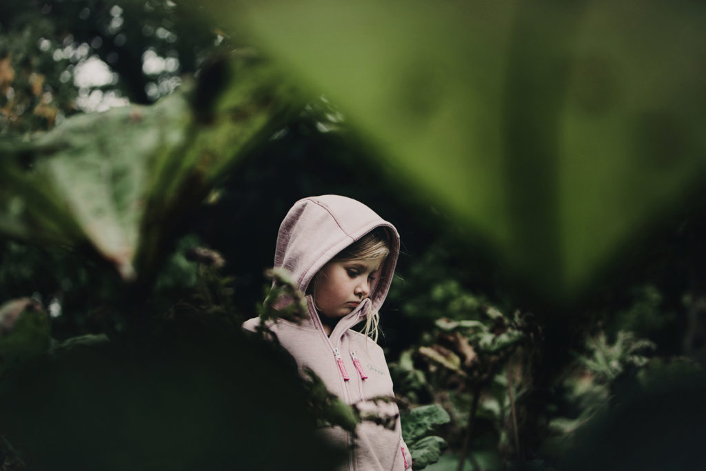 barn ute i skogen bland löv