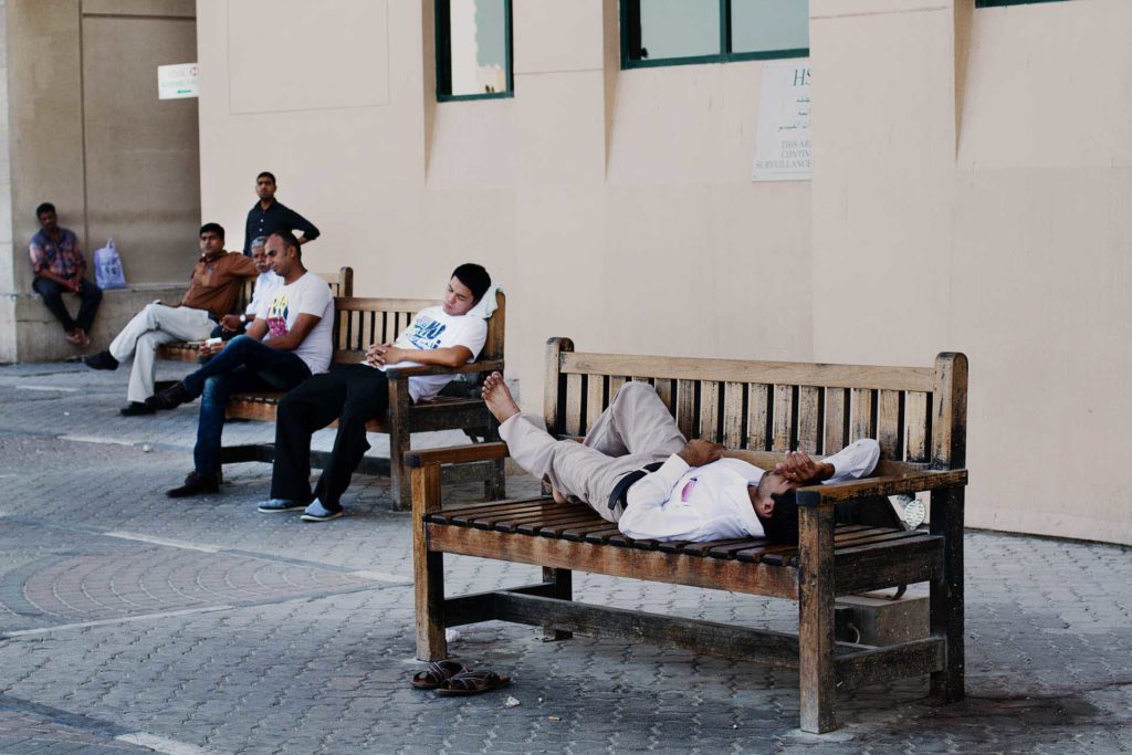 Fotokomposition Män ligger och vilar på en bänk